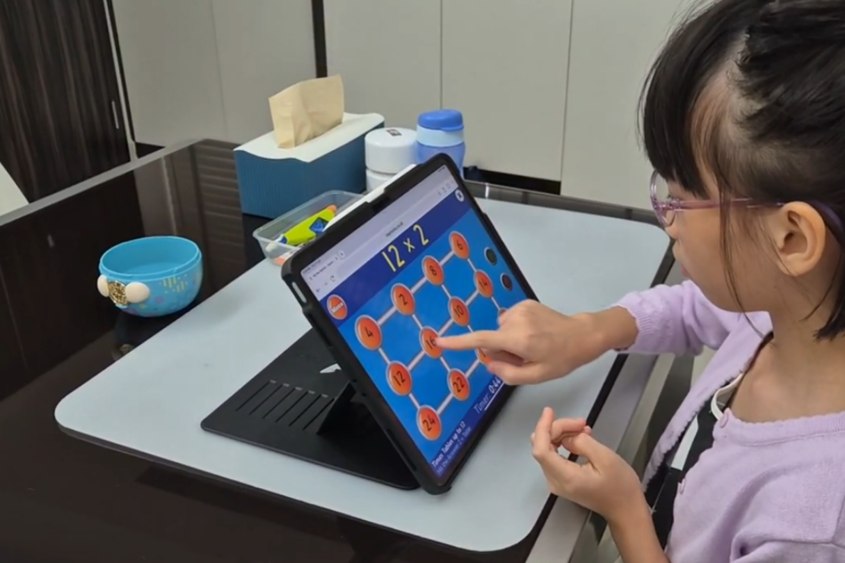 pecial needs tutor in Singapore guiding student during 1-to-1 special needs tuition session using visual learning tools.