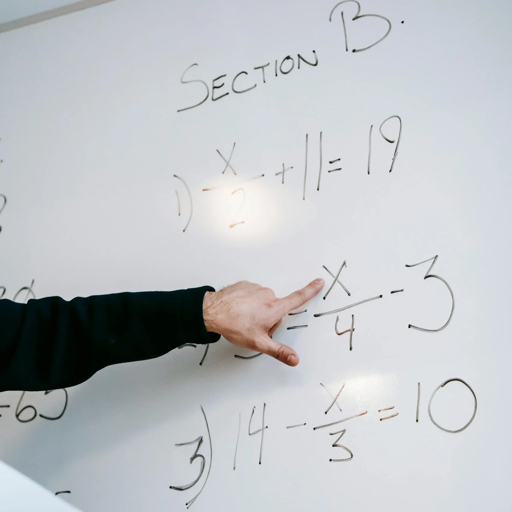 Tutor explaining math equations on a whiteboard during PSLE and O-Level tuition in Singapore, helping students strengthen exam techniques and accuracy.